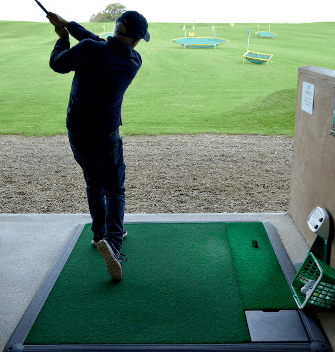 a golfer practicing on the driving range at Basset Down Complex