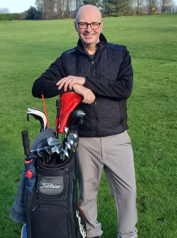 A picture of Piotr Ptaszek with his golf bag on the golf course